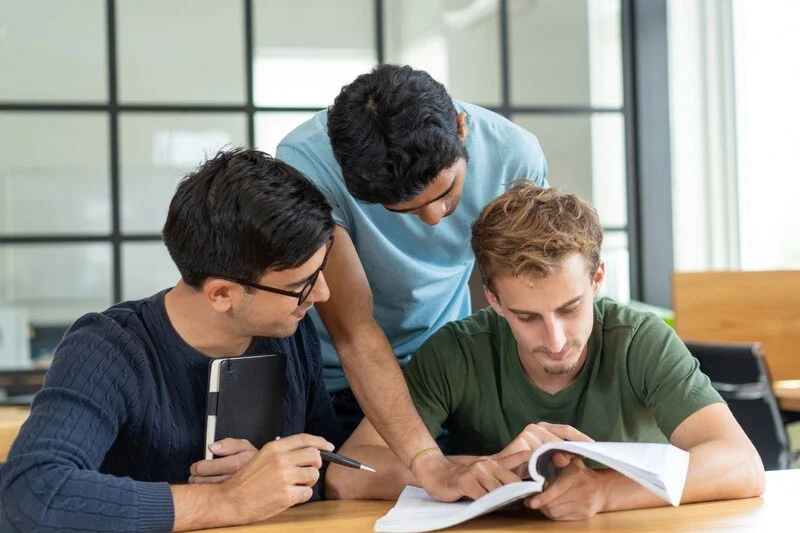 A Group of Three Students Studying Together in a Collaborative Setting